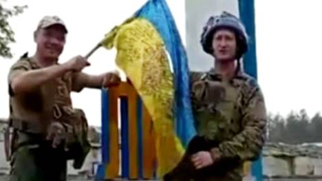 Sotilaat kiinnittivät Ukrainan lippua Lymanin kaupungin kylttiin lauantaina jaetussa Ukrainan presidentin kanslian julkaisemassa videossa.