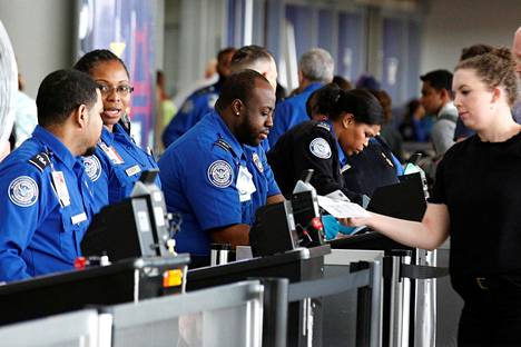 Yhdysvallat suunnittelee pyytävänsä matkustajilta jatkossa sosiaalisen median käyttötietoja. Kuvassa viranomaiset lähtöselvittävät matkustajia John F. Kennedyn kansainvälisellä lentokentällä toukokuussa.