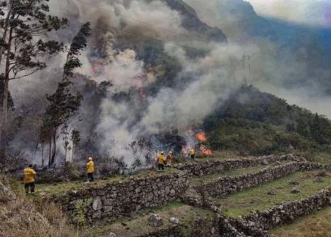 Machu Picchun alueviran­omaisten kuvassa näkyy, kuinka inkaraunioita uhannutta maastopaloa sammutettiin torstaina. 