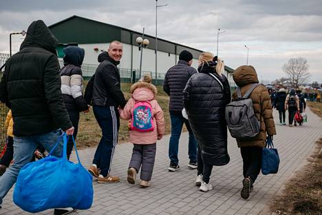 Ukrainalaisia pakenemassa Puolan rajan yli Medykassa helmikuussa pian Venäjän hyökkäyksen jälkeen. Suomeen on päätynyt lähes 40 000 sotaa paennutta ukrainalaista.