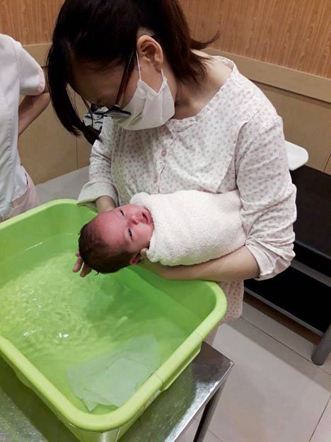 Yi-Ping Liao washes the baby at home.