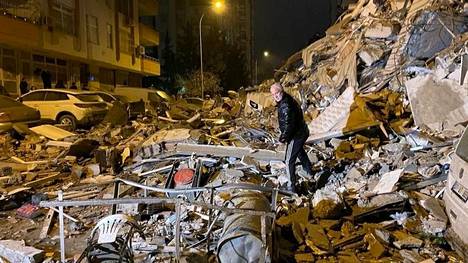 Mies tutki sortuneen rakennuksen jäännöksiä Turkin Nurdagissa maanantaiaamuna.