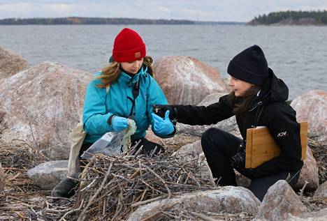 Suomen ympäristökeskuksen tutkijat Pinja Näkki (vas.) ja Anni Jylhä-Vuorio tutkivat merimetson pesistä löytyneitä muoviroskia Kotkassa syyskuussa 2021.