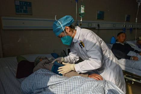 Hoitaja koronapotilaan luona sairaalassa Fuyangin kaupungissa Kiinassa 4. tammikuuta.
