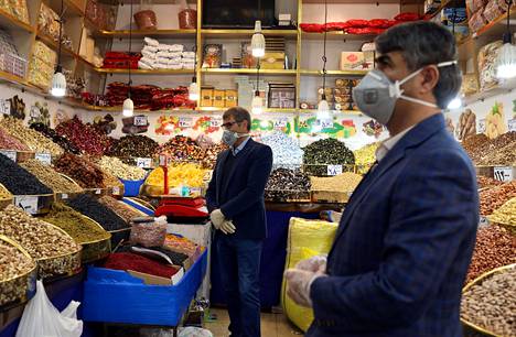 Pähkinäkaupan työntekijät olivat varautuneet hengityssuojaimin ja hanskoin Teheranissa tiistaina.