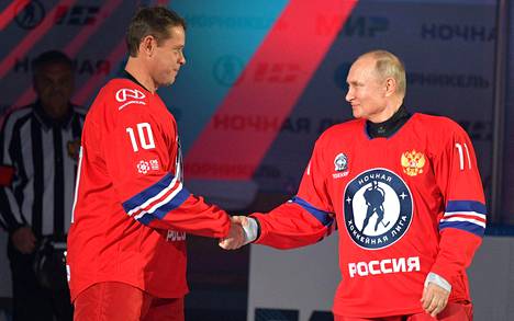 Presidentti Vladimir Putin (oik.) kätteli entistä huippujääkiekkoilijaa Pavel Burea ennen ottelua.