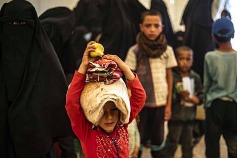 Lapsi kantoi leipänyyttiä päänsä päällä al-Holin leirillä Syyriassa kesäkuun alussa.