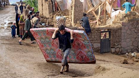 Asukkaat raivasivat syöksytulvien jälkiä pahoin vaurioituneessa Chaghcharānin kaupungissa lauantaina.