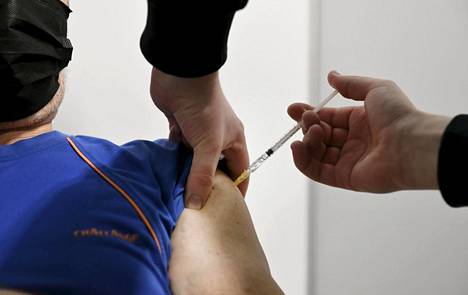 Hoitaja antaa rokotuksen Helsingin kaupungin keskiviikkona avautuneessa koronarokotuspisteessä Helsingin Messukeskuksessa.