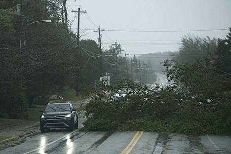Auto ohitti Fiona-hurrikaanin kaatamaa puuta Cape Bretonin saarella Nova Scotiassa lauantaina. 