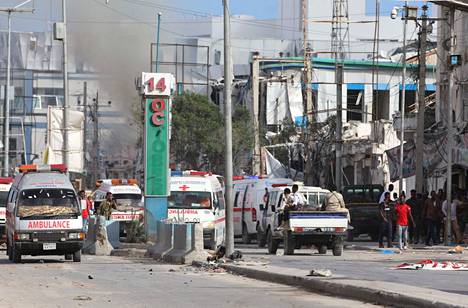 Pelastushenkilökunta raivasi risteysaluetta pommi-iskujen jälkeen Mogadishussa lauantaina.