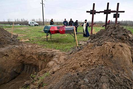 Ortodoksipappi siunasi kolmihenkisen perheen hautaan Butšassa 22. huhtikuuta. Venäläiset sotilaat väitetysti tappoivat perheenjäsenet, kun nämä olivat suuntaamassa pois kaupungista.
