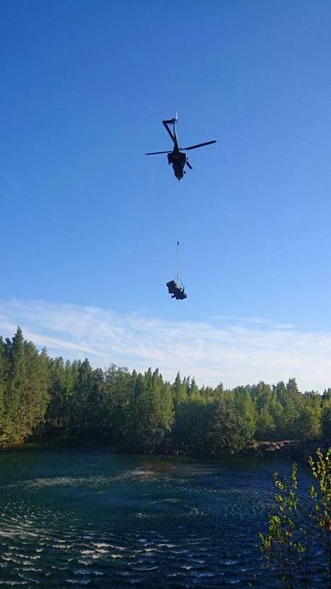 Helikopteri kuljetti autot kuivalle maalle vähän matkan päähän lammesta.