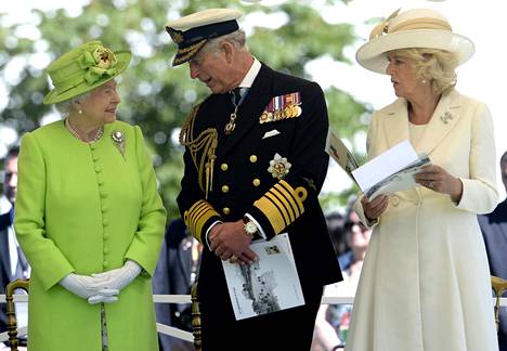 Kuningatar Elisabet, kuningas Charles ja hänen vaimonsa Camilla hautausmaalla Normandian maihinnousun 70. muistopäivänä kesäkuussa 2014. Elisabet on pukeutunut limenvihreään asuun. 