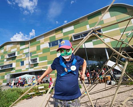Elias Heikkinen kiipeili Kivistön kyläjuhlilla koulunsa pihalla. Viime vuonna hän kärsi pääkivusta sisäilmaongelmien takia, mutta maanantaina hän pääsee korjattuihin luokkiin.