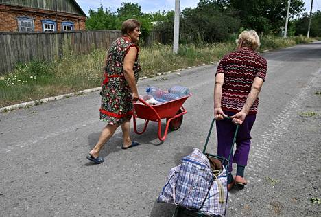 Paikalliset kuljettivat kaivovettä Siverskin kaupungissa Donetskin alueella 30. kesäkuuta.