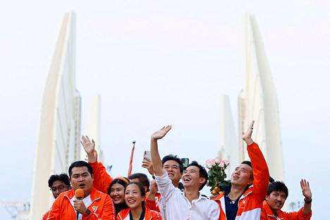 Puoluejohtaja Pita Limjajoenrat (keskellä) juhli vaalivoittoa Liike eteenpäin -puolueen kanssa maanantaina Bangkokissa.