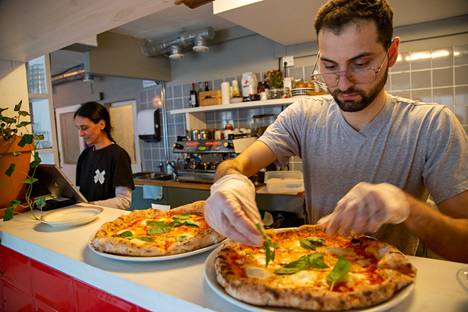 Kahvila-ravintola Fasellin pitäjä Nikolay Peytchev viimeistelee pizzaa, taustalla toinen omistaja Nati Contreras.
