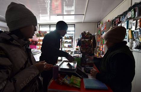 Ihmiset tekivät ostoksia sähkökaton aikana Kirgisian pääkaupungissa Biškekissä tiistaina.