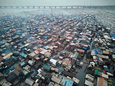 The above-water part of the Makoko slum.  In the background looms the bridge that leads to the most expensive areas of Lagos, Lagos Island and Victoria Island.