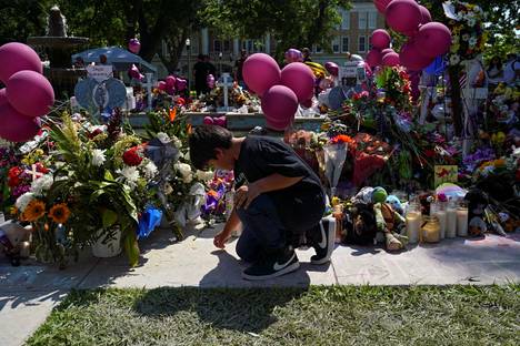 Zechariah Garza kirjoittaa viestiä joukkoampumisen uhrien muistomerkillä Uvaldessa, Texasissa, Yhdysvalloissa 29. toukokuuta 2022. 