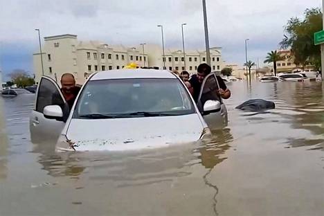 People were pushing the car in the flood water.