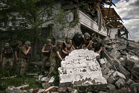 Ukrainalaissotilaita tarkastamassa Venäjän tulituksessa tuhoutunutta varastoa Lysitšanskissa 17. kesäkuuta. Heinäkuun alussa Lysitšanskia puolustaneet ukrainalaiset joutuivat vetäytymään kaupungista välttääkseen piirityksen.