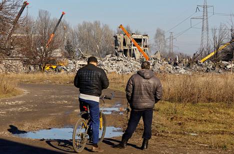 Miehet katselivat tuhotun ammattikoulun raunioita Donetskin Makijivkassa. Ukrainalaisjoukot iskivät uudenvuodenaattona rakennukseen, jossa oli majoittuneena venäläissotilaita. 