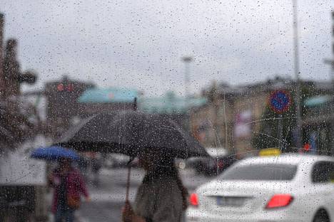 Jalankulkijoita ja liikennettä sateisessa säässä Helsingissä 28. heinäkuuta 2021
