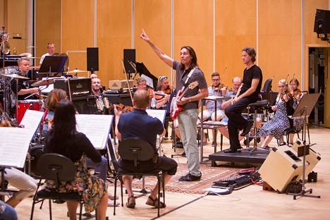 The collaboration between conductor Jukka Iisakkila (right) and guitarist Steve Vai began in August 2018 at the Huvila concert during the Helsinki holiday weeks, where the Tapiola Sinfonietta performed Vai's music.  Photo of the rehearsals for the concert.