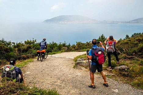 Vaeltajia ihailemassa Galician maakunnan läntisimmässä kolkassa sijaitsevaa Finisterrean niemeä. Paikallisella galegolla se on nimeltään Cabo Fisterra.