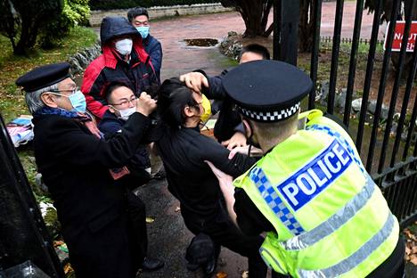 Kiinan Manchesterin-konsulaatin portilla konsulaatin työntekijät pahoinpitelivät mielenosoittajaa sunnuntaina.