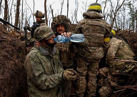 Ukrainalainen sotilas juotti vangiksi otetulle venäläissotilaalle vettä lähellä etulinjaa Bahmutissa torstaina.