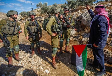 Palestiinalaismies heilutti Palestiinan lippua Israelin sotilaiden edessä Beit Dajanin kylässä Nabluksen lähellä 11. marraskuuta. 