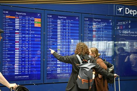 Matkustajat tarkistivat lentotietojaan digitaalisilta näytöiltä kesäkuussa 2022.