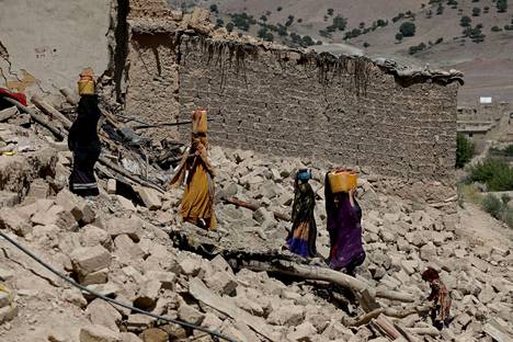 Naiset kantoivat vesikanistereita maanjäristyksen jälkeen Wor Kalin kylässä 25. kesäkuuta. 