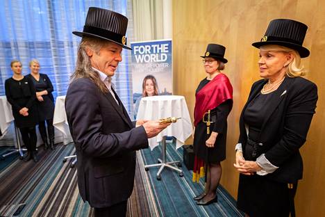 Bruce Dickinsonille luovutettiin keskiviikkona Helsingin yliopiston kunniatohtorin hattu ja miekka. Kuvassa oikealla juhlamenojen ohjaaja Hanna Korsberg (punaisessa nauhassa) sekä promoottori Marja-Liisa Riekkola.