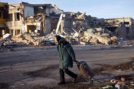 Ikääntynyt ukrainalaisnainen veti kärryään Bahmutin raunioiden keskellä aiemmin joulukuussa.