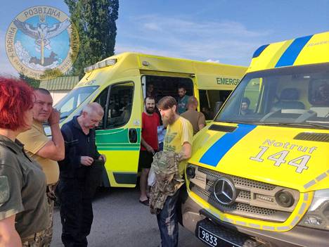 Ukrainalaissotilaita seisoo ambulanssien vieressä Zaporižžjan alueella Ukrainan vaihtaessa vankeja Venäjän kanssa 29. kesäkuuta.