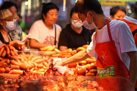 Kauppias myi lihaa Shenyangin markkinoilla Kiinan koillisosassa maanantaina 9. elokuuta. 