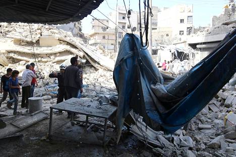 Ihmiset tutkivat ilmaiskujen tuhoja Aleppossa keskiviikkona.
