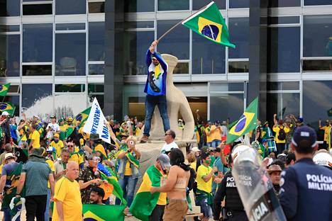Mielenosoittajat heiluttivat Brasilian lippuja presidentinpaltsin edessä.