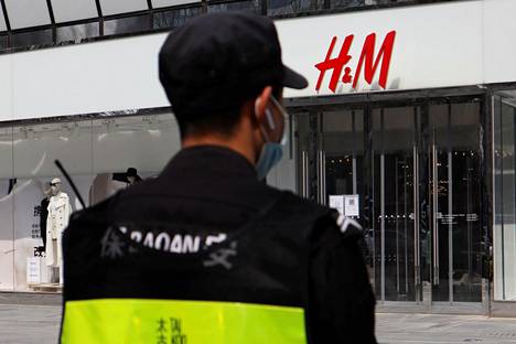 Turvamies tarkkaili tilannetta Pekingissä sijaitsevan H&M-vaatekaupan edustalla torstaina.
