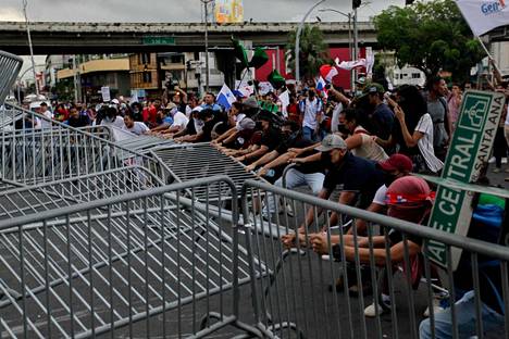 Mielenosoittajat kaatoivat mellakka-aitoja Panaman pääkaupungissa 12. heinäkuuta. 