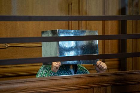 Murhasta syytetty mies peitti kasvonsa pahvilla oikeudenkäynnin ensimmäisenä päivänä Berliinissä 10. elokuuta 2021.