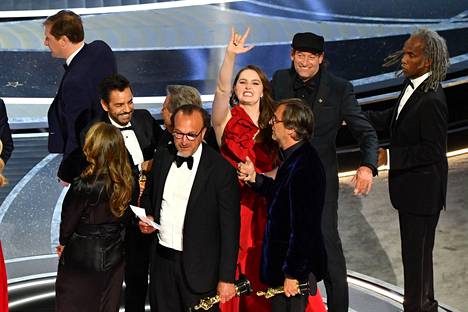 Coda-elokuvan työryhmä juhli parhaan elokuvan Oscar-voittoa Dolby-teatterin lavalla myös viittoillen.