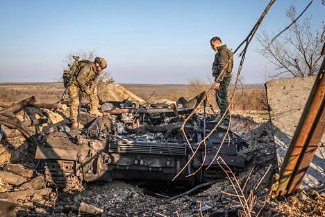Ukrainian soldiers inspect a destroyed Russian tank in Snihurivka in November.