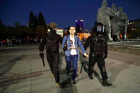 Poliisit taluttivat liikekannallepanoa vastustanutta miestä Novosibirskissa keskiviikkona.