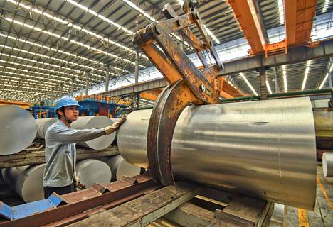 työntekijä käytti nosturia alumiinilevyrullan siirtelyyn tehtaalla Etelä-Kiinan Nanningissa huhtikuussa. Kiinan talouden arvioidaan hidastuneen vuoden ensimmäisellä neljänneksellä.