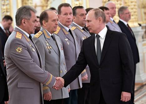 Venäjän presidentti Vladimir Putin kättelee puolustusministeri Sergei Šoigua huhtikuussa 2019. Šoigun vieressä ovat FSB:n johtaja Aleksandr Bortnikov sekä kansalliskaartin johtaja Viktor Zolotov.